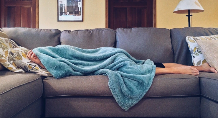 Persona enferma cubierta en el sofa
